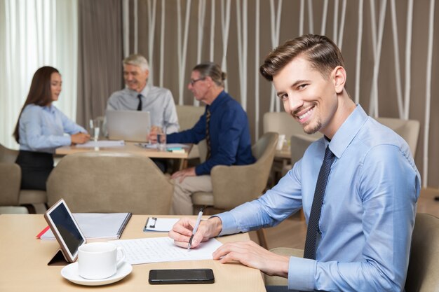 Hombre sonriente acertado joven que trabaja en café