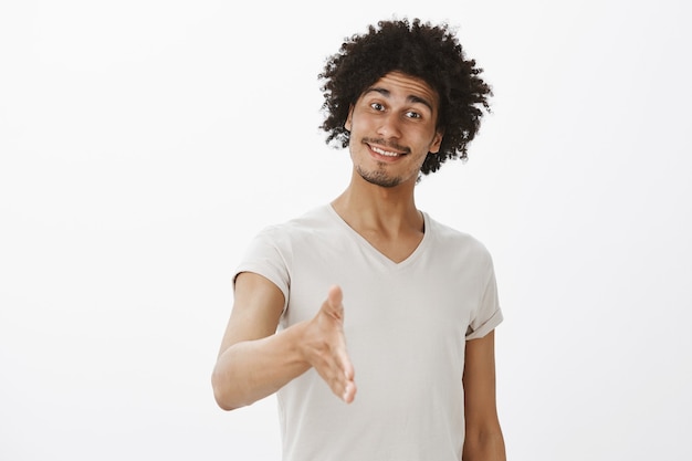 Hombre sonriente amable alegre extender la mano para un apretón de manos, gusto en conocerte