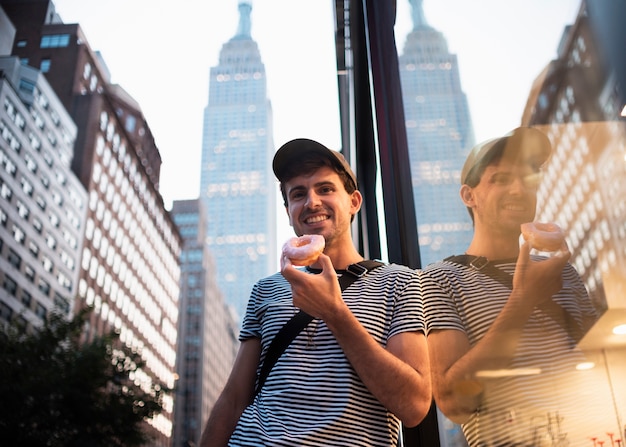 Hombre sonriente de ángulo bajo con donut