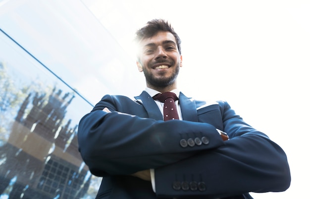 Foto gratuita hombre sonriente de ángulo bajo mirando a cámara