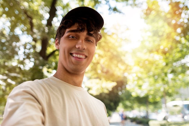 Foto gratuita hombre sonriente de ángulo bajo tomando selfie