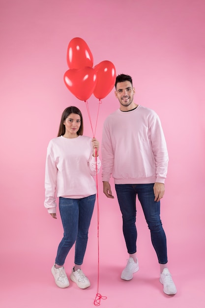 Hombre sonriente y atractiva mujer con globos