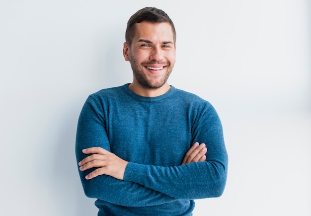 Hombre sonriente con los brazos cruzados posando