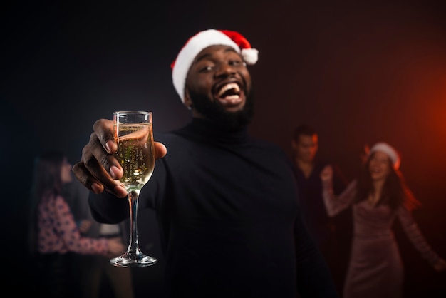 Hombre sonriente brindando con champán para año nuevo