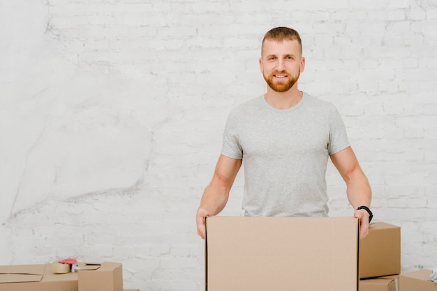 Foto gratuita hombre sonriente con caja de cartón