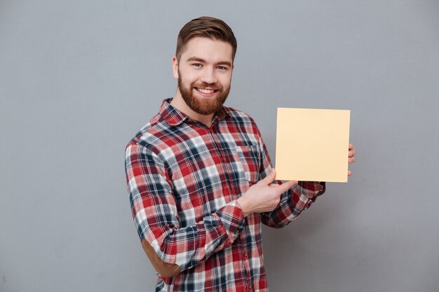 Hombre sonriente en camisa con tablero en blanco