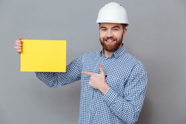 Foto gratuita hombre sonriente en casco con tablero en blanco