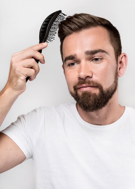 Hombre sonriente cepillándose el pelo