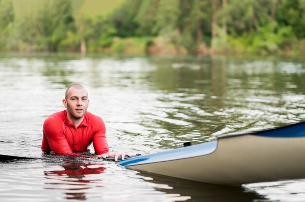 Hombre sonriente cerca de kayak