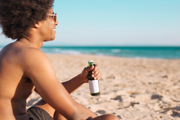 Hombre sonriente con cerveza en mano