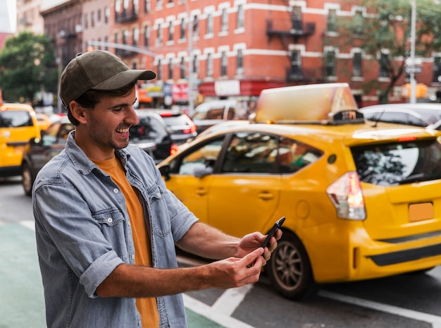 Hombre sonriente en la ciudad con móvil