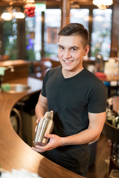 Hombre sonriente con coctelera