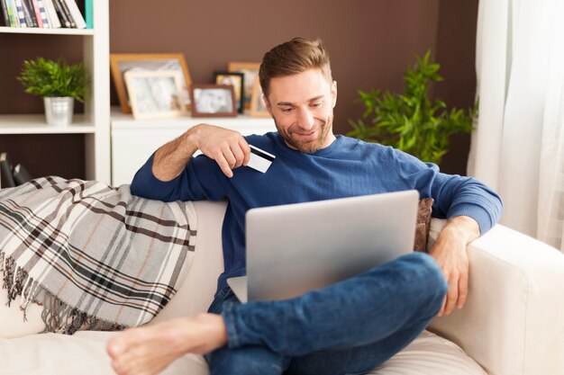 Hombre sonriente durante las compras online en casa