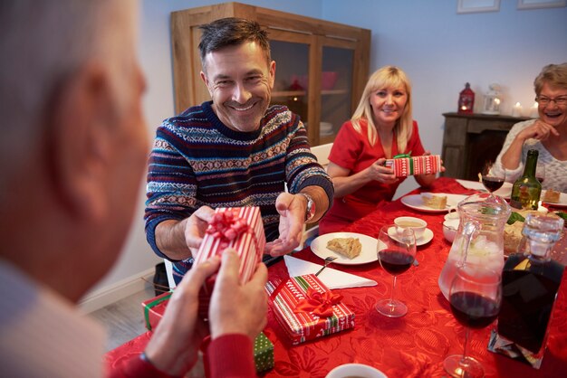 Hombre sonriente dando un regalo a su padre