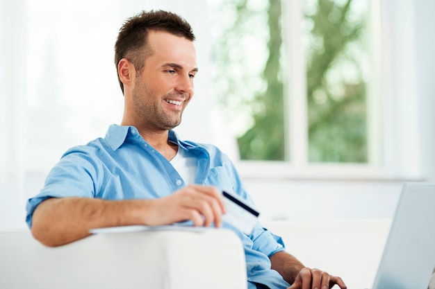 Hombre sonriente disfrutando del comercio electrónico