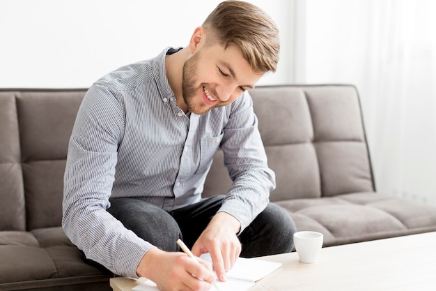 Hombre sonriente escribiendo