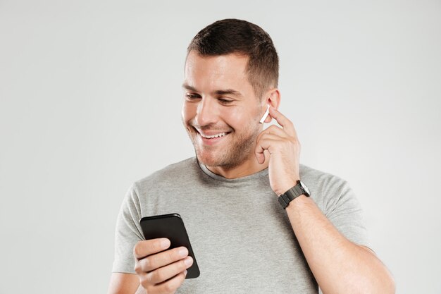 Hombre sonriente escuchando música con auriculares.