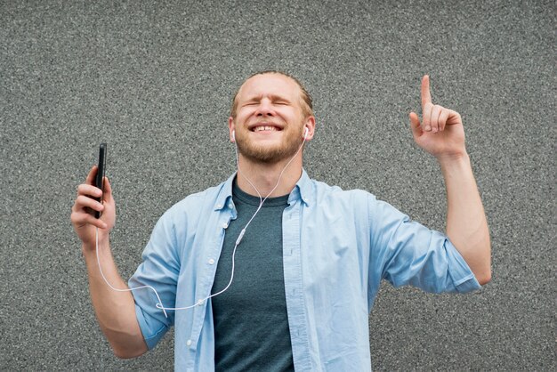 Hombre sonriente escuchando música en auriculares