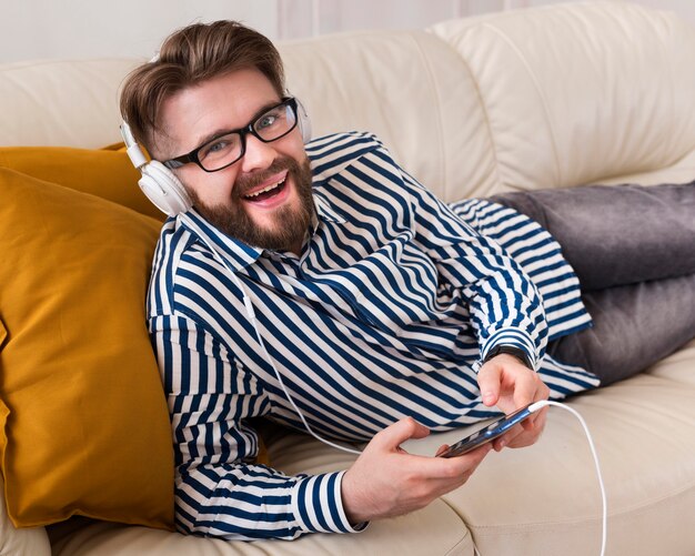 Hombre sonriente escuchando música con auriculares
