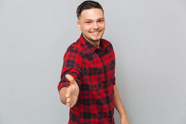 Foto gratuita hombre sonriente extiende su mano para un apretón de manos