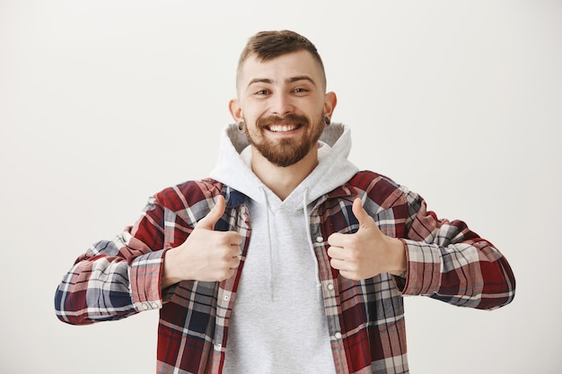 Foto gratuita hombre sonriente feliz complacido mostrando el pulgar hacia arriba, alabando el buen trabajo, bien hecho