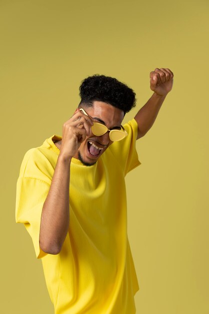 Hombre sonriente con gafas de sol de tiro medio