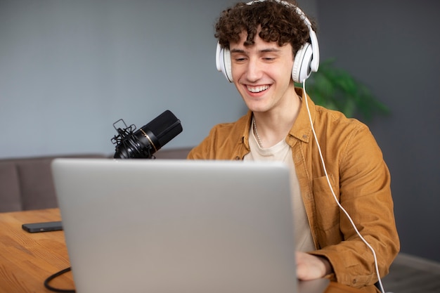 Hombre sonriente grabando vista lateral de podcast