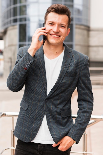 Hombre sonriente hablando por teléfono mientras se dirigía al trabajo