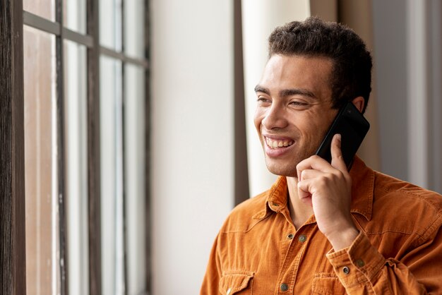 Hombre sonriente hablando por teléfono