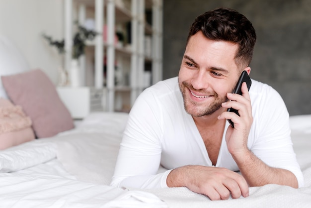Hombre sonriente hablando por teléfono