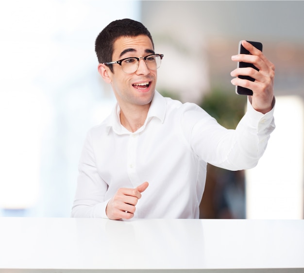 Hombre sonriente haciendose una foto con el móvil