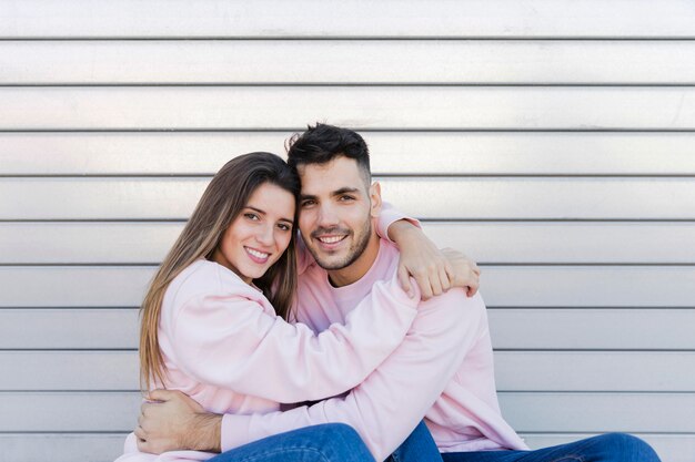 Hombre sonriente joven que abraza con la mujer feliz atractiva