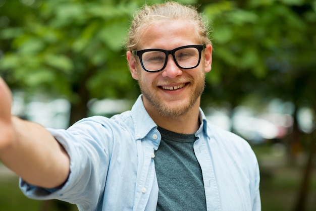 Foto gratuita hombre sonriente llegando a su mano para posar