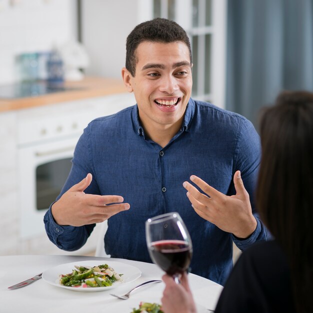 Hombre sonriente mirando con amor a su novia en el interior