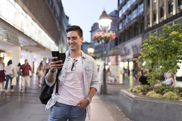 Hombre sonriente mirando la pantalla del teléfono móvil