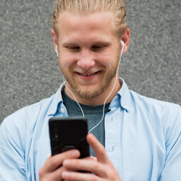 Hombre sonriente mirando smartphone