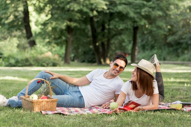 Hombre sonriente mirando a su novia en picnic