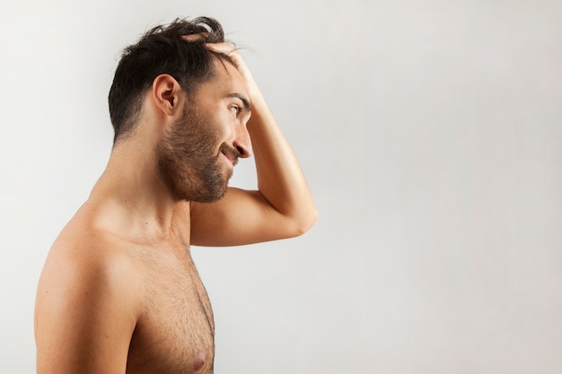 Foto gratuita hombre sonriente mirándose al espejo