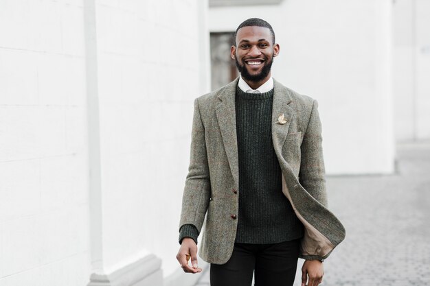 Hombre sonriente de moda posando al aire libre