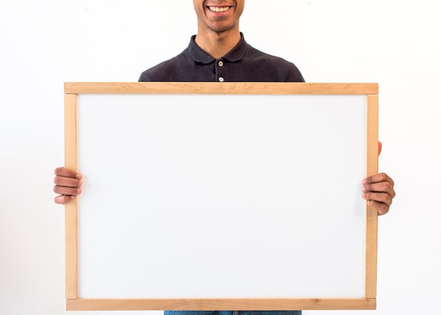 Hombre sonriente mostrando pizarra vacía en blanco