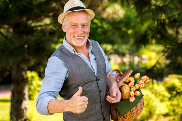 Hombre sonriente mostrando pulgares arriba tiro medio