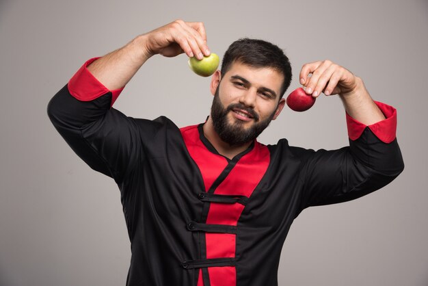 Hombre sonriente mostrando rodajas de manzana fresca.