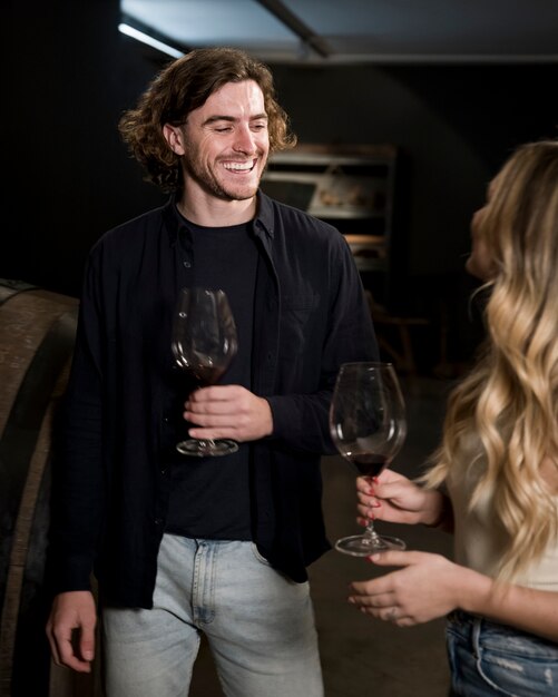 Hombre sonriente y novias degustando vino