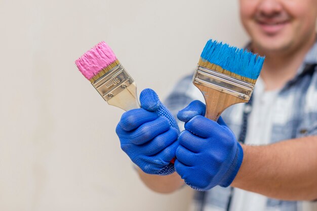 Hombre sonriente con pincel rosa y azul