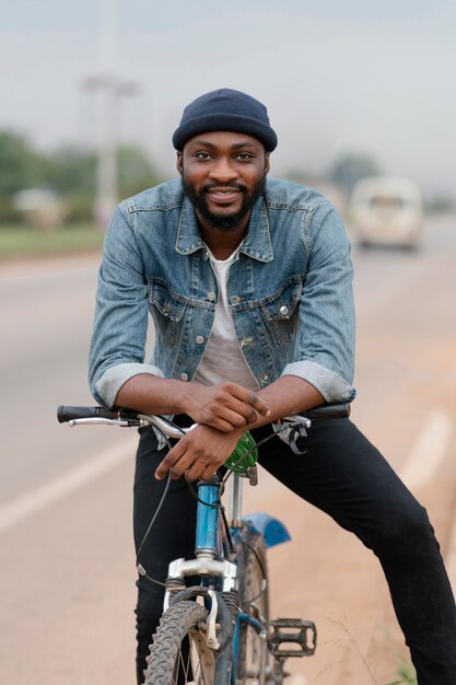 Hombre sonriente posando con bicicleta