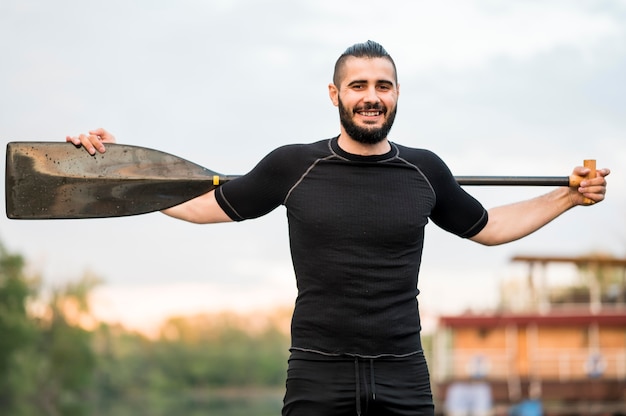 Foto gratuita hombre sonriente posando con remo