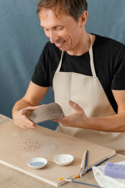 Foto gratuita hombre sonriente de primer plano haciendo cerámica
