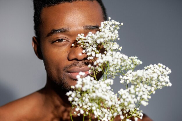 Hombre sonriente de primer plano posando con flores