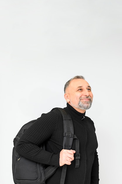Hombre sonriente que sostiene una mochila