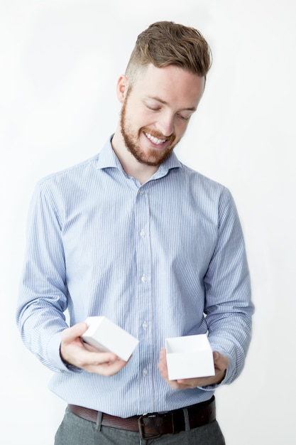 Foto gratuita hombre sonriente que sostiene la pequeña caja vacía